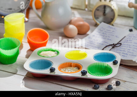 Zubereitung für süße Muffins mit Heidelbeeren auf alten weißen Tisch Stockfoto