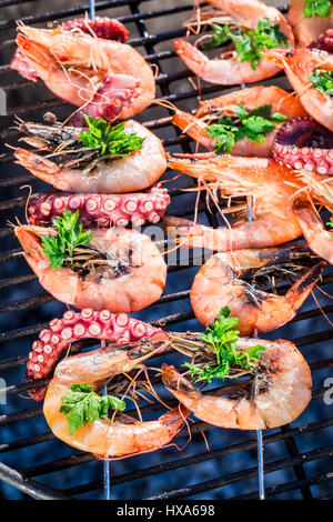 Frische Meeresfrüchte-Spieße mit Zitrone und Petersilie auf grill Stockfoto