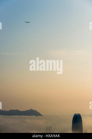 Die Skyline der Stadt fällt in niedrige Wolken und Nebel Meer bei Sonnenaufgang über den Victoria Harbour in Hongkong, China gesehen. Stockfoto