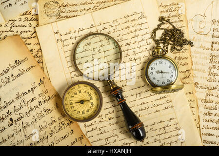 Taschenuhr-Kompass und Lupe auf alte Briefe Stockfoto