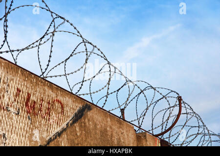 Stacheldraht Zaun Detail gegen den blauen Himmel genommen Closeup. Stockfoto