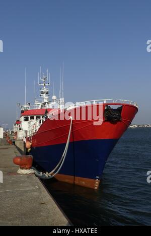 Roten Fischerboot neben der Werft an den Fischerhafen von Lorient, Bretagne Frankreich. Blick vom Bogen mit Festmacher gesichert auf Poller Stockfoto