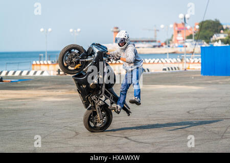 WLADIWOSTOK, Russland - 5. Oktober 2013: Motorrad Stuntfahrer erklingt in einem lokalen Motorrad-Show. Stockfoto