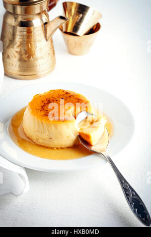 Creme Caramel auf einem Teller serviert auf einem Tisch Stockfoto