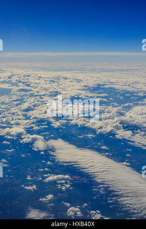 Eine Luftaufnahme über den Wolken aus dem Fenster eines Flugzeugs Stockfoto