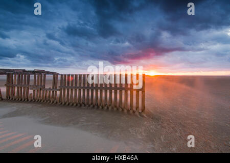 Holzzäune am Strand in Tarifa, Spanien Sonnenuntergang nach dramatischen Sturm. Berühmte Surf- und Kitespot bekannt für starke Winde Stockfoto