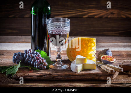 Frischer Rotwein mit Trauben und Flasche Stockfoto