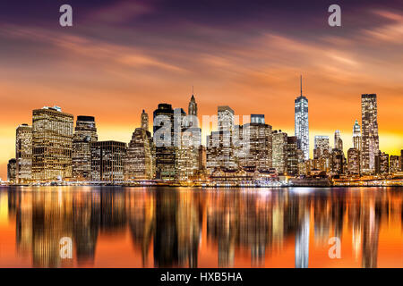 Sonnenuntergang über New York City-Financial District von Brooklyn, mit Skyline von Reflexionen im East River aus gesehen Stockfoto