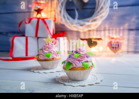 Zwei kleine Muffins auf alten Holztisch für Weihnachten dekoriert. Stockfoto