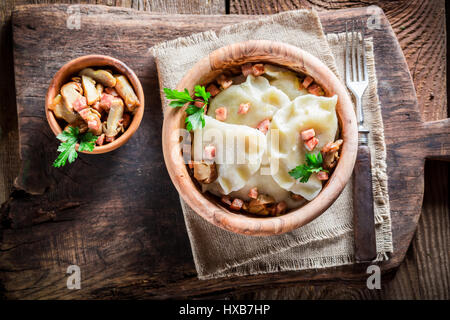 Gekochte Teigtaschen mit Mushrroms auf alten Holztisch Stockfoto