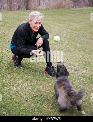 Fit Woman fangen mit ihrem Hund spielen Stockfoto