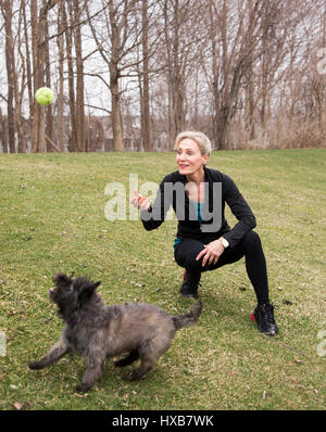 Fit Woman fangen mit ihrem Hund spielen Stockfoto