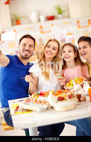 Familie nehmen Selfie in Küche beim Färben von Eiern zu Ostern Stockfoto