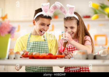 Fröhliche Kinder Färbung Eiern für Osterfeier Stockfoto