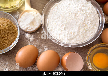 Eiern und Mehl Grundzutaten für das Backen auf Holztisch Stockfoto