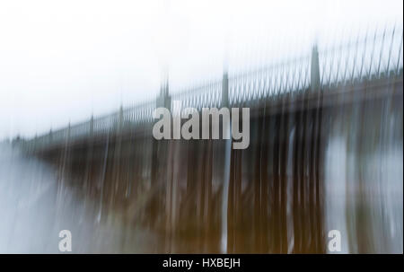 Verschwommenes Bild eines langen antiken Brücke mit einem schmiedeeisernen Zaun in den Nebel, mit einer langen Belichtungszeit gemacht. Das Konzept der ein langer harter Weg, Schwierigkeiten und Depression. veränderten Bewusstseinszustand. Stockfoto