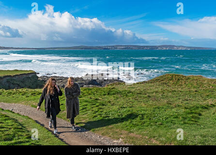 zwei junge Frauen zu Fuß entlang der South West Coast Path bei Godrevy in Cornwall, England, Vereinigtes Königreich, Stockfoto