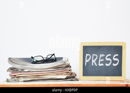 Zeitung stack als nächstes eine Tafel mit dem Text in geschriebene Presse. Kommunikations-Konzept. Leere Kopie Platz für Text des Herausgebers. Stockfoto