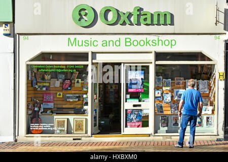 Altstadt shopping Straße Oxfam Nächstenliebe Musik Shop & Buchhandlung Ladenfront mit Mann Schaufensterbummel Chelmsford High Street Essex England UK Stockfoto