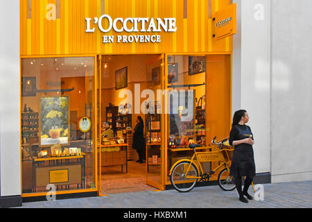 L ' Occitane En Provence Frontscheibe Schaufenster der Kosmetik & Beauty-Produkte mit Shop Verkäuferin Person Demonstrator stehend auf Bürgersteig Stockfoto