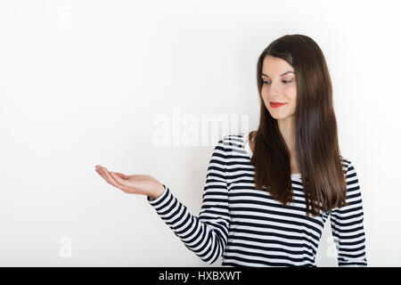 Mädchen zeigen leere Speicherplatz auf der offenen Hand palm für Text oder Produkt, weisser Hintergrund. lächelnde Mädchen präsentieren. vorschlagen Produkt. Werbung Stockfoto