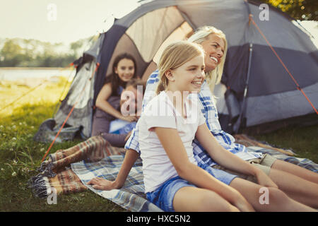 Lächelnd Familie entspannen außerhalb Camping Zelt Stockfoto