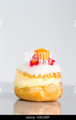 Windbeutel Kuchen oder Profiterole gefüllt mit Schlagsahne serviert mit Früchten und Dekoration und Vereisung Blume Stockfoto