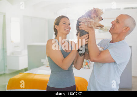 Älteres Paar spielen mit Hund Stockfoto