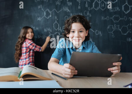 Pädagogische Experimente zu genießen. Brainy Lächeln begeistert Jugendliche in der Schule sitzen und Notizen auf die Blackboa Chemieunterricht genießen Stockfoto