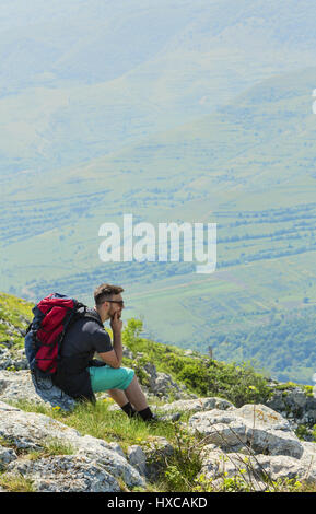 Bild von einem Wanderer ruht auf Felsen und in der Ferne in Bergen suchen. Ort: Apuseni-Gebirge, Siebenbürgen, Rumänien. Stockfoto