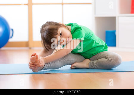 niedliche kleine Mädchen stretching im Fitness-Studio Stockfoto