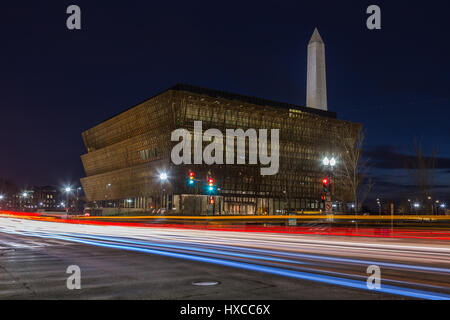 Verkehr schafft Lichtspuren in der Dämmerung außerhalb des Smithsonian National Museum of African American History und Kultur (NMAAHC) in Washington, DC. Stockfoto