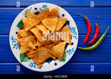 Nachos Chips und Chilischoten auf mexikanische Platte über blaue Holztisch Stockfoto