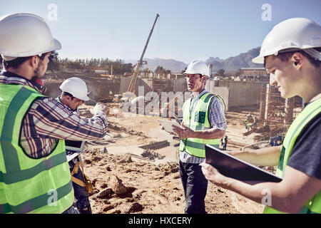 Die Bauarbeiter und Ingenieure treffen bei Sunny Baustelle Stockfoto