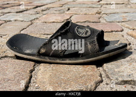 Eine alte Sandale liegt auf der Straße, im alten Sandale ist unterwegs |, Eine Alte Sandale Liegt Auf der Straße | Eine alte Sandale ist unterwegs | Stockfoto