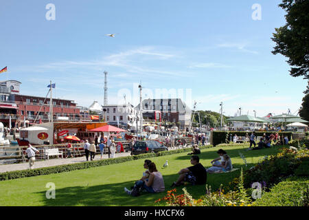 Touristen genießen das sommerliche Wetter an der Promenade im Hafen von Warnem? Nde, Touristen genießen das Summer Wetter auf der Promenade am Hafen von W Stockfoto