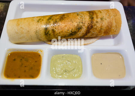 Masala dosa auf einem weißen partitionierte Platte mit Kokos Chutney und Sambar Stockfoto