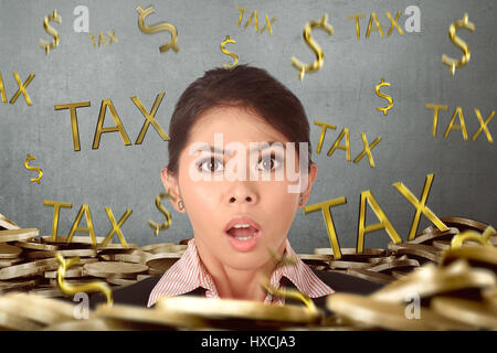 Schöne asiatische Geschäftsfrau betont wegen Steuerzahlung mit Wand-Hintergrund Stockfoto
