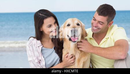 Digitalen Verbund aus paar mit Hund gegen verschwommen Strand Stockfoto