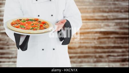 Digitalen Verbund von Koch mit Pizza gegen verschwommen Holzplatte Stockfoto