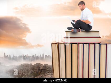 Digitalen Verbund von Mann mit Laptop sitzen auf Bücher gestapelt von entfernten Stadt und Wolken Stockfoto