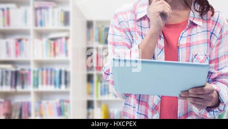 Digitalen Verbund aus Womans Hände halten Tablet in Bibliothek Stockfoto