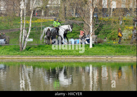 London, UK. 27. März 2017. UK-Wetter: Montiert Polizei Patrouille Wanderwege. Touristen und Büroangestellte genießen das schöne Wetter und Sonnenschein im St. James Park. Bildnachweis: Stephen Chung/Alamy Live-Nachrichten Stockfoto