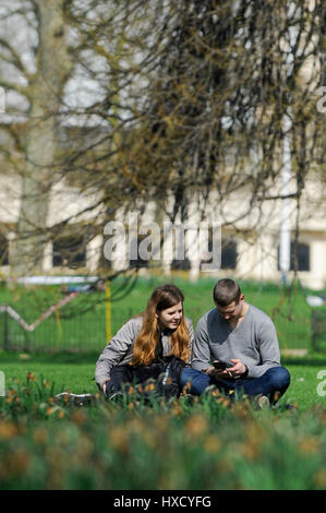 London, UK. 27. März 2017. UK-Wetter: Ein paar genießt ein Picknick. Touristen und Büroangestellte genießen das schöne Wetter und Sonnenschein im St. James Park. Bildnachweis: Stephen Chung/Alamy Live-Nachrichten Stockfoto