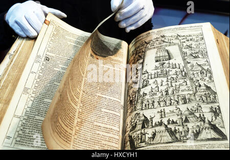 Leipzig, Deutschland. 26. März 2017. Ein Mann mit Handschuhen blättert eine Luther-Bibel von 1649, derzeit auf dem Display in der "Bibelmobil" (lit.) Bibel-Mobile), auf der Buchmesse in Leipzig, Deutschland, 26. März 2017. Rund 2.400 Aussteller präsentieren ihre neuesten Veröffentlichungen während der diesjährigen Buchmesse. Foto: Jens Kalaene/Dpa-Zentralbild/ZB/Dpa/Alamy Live News Stockfoto