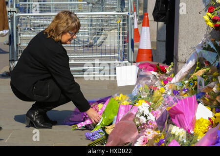 Westminster London, UK. 27. März 2017. Eine Frau verlässt Blumen außerhalb Palast von Westminster. Bildnachweis: Dinendra Haria/Alamy Live-Nachrichten Stockfoto