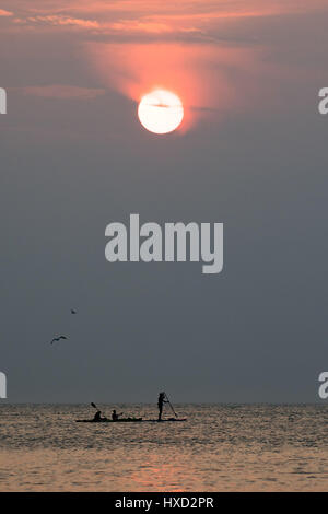 Aberystwyth, Wales, UK. 27. März 2017. UK-Wetter: Menschen paddle-Boarding und Kajakfahren auf das flache Meer bei Sonnenuntergang an der Cardigan Bay, Wales, am letzten Abend warme Schönwetterperiode bevor unruhige und feuchtere Bedingungen in den nächsten Tagen im Rollen Bildnachweis: Keith Morris/Alamy Live News Stockfoto