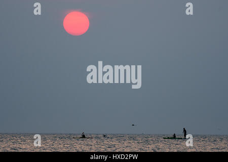 Aberystwyth, Wales, UK. 27. März 2017. UK-Wetter: Menschen paddle-Boarding und Kajakfahren auf das flache Meer bei Sonnenuntergang an der Cardigan Bay, Wales, am letzten Abend warme Schönwetterperiode bevor unruhige und feuchtere Bedingungen in den nächsten Tagen im Rollen Bildnachweis: Keith Morris/Alamy Live News Stockfoto