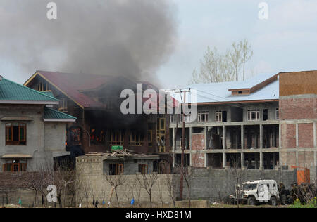 Srinagar, Kaschmir. 28. März 2017. Indische Armee unter Position während des Betriebs als Feuer wabert aus einem Wohnhaus, das während einer Schießerei zwischen militanten und indische Soldaten in Durbagh Dorf Chadoora, 15 km von Srinagar gesprengt wurde. Drei Zivilisten und eine militante getötet und ein indischer Soldat während einer 10-Stunden-lange Schießerei verletzt. Bildnachweis: Sofi Suhail/Alamy Live-Nachrichten Stockfoto