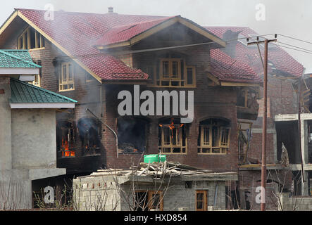 Srinagar, Kaschmir. 28. März 2017. Bild aufgenommen am 28. März 2017 zeigt Rauch und Flammen kommen aus einem Wohnhaus während einer Schießerei im Dorf Durbugh im Chadoora Budgam Bezirk, ca. 22 km südlich der Stadt Srinagar, der Sommerhauptstadt von Kaschmir. Mindestens drei Jugendliche wurden getötet und 13 weitere verletzt Dienstag nachdem Demonstranten in der Nähe einer Schießerei in unruhigen Kaschmir Regierungstruppen beschossen, teilte die Polizei mit. Bildnachweis: Javed Dar/Xinhua/Alamy Live-Nachrichten Stockfoto